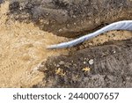 Small photo of Construction photo of natural turf athletic field vertical edge drain profile, drainage panel between baseball - softball infield clay and natural grass field.
