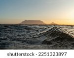 Small photo of Abstract Water Surface Lake Wave windy day.Texture of dark water during sunset. Water surface in focus. Selective focus. Sunset Cape Town Table Mountain and Lions Head blurry background.