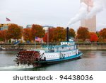 Ferry or steam boat in Portland on Willamette river under steam with two American flags on an overcast day