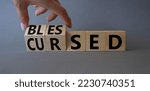 Small photo of Blessed vs Cursed word symbol. Businessman Hand turns cubes with word Cursed and changes it to word Blessed. Beautiful grey background. Religious and Blessed vs Cursed concept