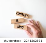 Content is king symbol. Concept words Content is king on wooden blocks. Businessman hand. Beautiful white background. Business and Content is king concept. Copy space.