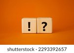Small photo of Question mark and exclamation mark symbol. Question mark and exclamation mark on wooden cubes. Beautiful orange background. Business concept. Copy space.