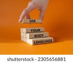 Use your Body Language symbol. Concept words Use your Body Language on wooden blocks. Businessman hand. Beautiful orange background. Business and Use your Body Language concept. Copy space