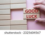 Good luck symbol. Wooden blocks with words Good luck. Businessman hand. Beautiful pink background. Business and Good luck concept. Copy space.