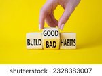 Small photo of Build Good or Bad Habits symbol. Businessman hand turns wooden cubes and changes the words Build Bad Habits to Build good Habits. Beautiful yellow background. Business concept. Copy space