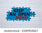 Keep an open mind symbol. White puzzle with words Keep an open mind. Beautiful blue background. Business and Keep an open mind concept. Copy space.