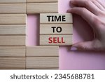 Small photo of Time to Sell symbol. Concept words Time to Sell on wooden blocks. Businessman hand. Beautiful pink background. Business and Time to Sell concept. Copy space. Concept