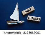 Small photo of Role changes symbol. Concept words Role changes on wooden blocks. Beautiful deep blue background with boat. Business and Role changes concept. Copy space.