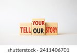 Small photo of Tell Your or Our story symbol. Wooden cubes with words Tell Our story and Tell Your story. Beautiful white background. Business concept. Copy space