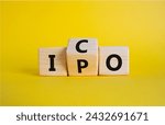 Small photo of ICO and IPO symbol. Wooden cubes with words ICO - initial coin offering and IPO - initial public offering. Beautiful yellow background. Business concept. Copy space