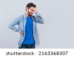 Small photo of Worried young man holding his forehead, Worried man isolated, tired man holding his head, man with headache