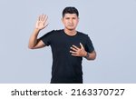 Small photo of Honest man raising his hand, a A guy raising his hand swearing, Man swearing honesty and devotion, young man raising a hand promising something