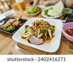 Small photo of Thai Spicy Green Mango Salad (Yum Mamuang) Thai salad features mangos, Crispy fried small fish and red onion, Tangy salad with Thai flavour and just a little spicy. Som tum, Thai Spicy salad