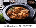 Small photo of Flemish Stew, stoofvlees, carbonnade, beef or pork, beer and onion stew in black bowl on dark rustic wooden table