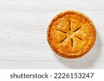 Small photo of Ground Beef Meat Pie with a flaky puff pastry double crust with hearty minced beef cooked with vegetables and seasoning in white baking dish on wood table, flat lay, free space