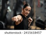 Small photo of Female boxer throwing a jab while shadowboxing in the gym