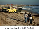 Small photo of SAN PEDRO, CA - FEB. 3: A heavily damaged biplane is towed off Cabrillo Beach following a mid-air collision Feb. 3, 2007. The pilot and beach goers were uninjured.