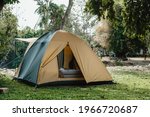 Camping picnic green tent campground in outdoor hiking forest.  Camper while campsite in nature background at summer trip camp. Adventure Travel Vacation concept