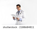 Small photo of Portrait of handsome positive doctor in medical gown and stethoscope holding tablet and smiling isolated on white background