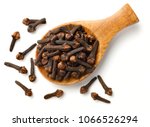 dried cloves in the wooden spoon, isolated on white background