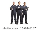 Full length portrait of three mechanic workers in uniforms isolated on white background
