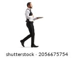 Full length profile shot of a waiter carrying a silver tray and walking isolated on white background
