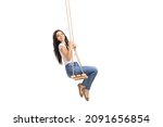 Side shot of a young brunette swinging on a wooden swing and looking at the camera isolated on white background