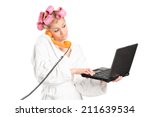 Woman in bathrobe talking on phone and working on laptop isolated on white background