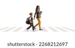 Small photo of Full length profile shot of a woman carrying books and holding hands with a schoolboy on a pedestrian crossing isolated on white background