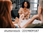 Small photo of Laughing black female playing fun cards games for time with diverse friends, enjoying pastime activity sitting at table at home. Happy multiethnic men and women playing board game in living room.