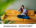 Small photo of Portrait of pensive thoughtful young woman holding smartphone looking away lost on sad thoughts waiting first step from man, call or text message or date invitation from boyfriend feels jealousy.