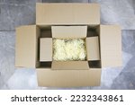 Small cardboard box open top view with corrugated cardboard paper pieces instead bubble wrap in big cardboard box delivered parcel. Zero waste,multiply using cardboard box, recycle,delivery,shopping