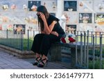Small photo of Weeping woman with sunglasses, black dress and hand on her head