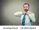 Small photo of Closeup portrait of tired businessman taking off his tie off. Mixed race bearded model isolated on gray studio wall background with copy space. Horizontal image.