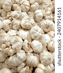 Small photo of White garlic pile texture. Fresh garlic on market table closeup photo. Vitamin healthy food spice image. Spicy cooking ingredient picture. Pile of white garlic heads. White garlic head heap top view