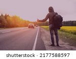 a hitchhiker catches a car on the road