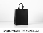 Black shopping bag on white background. Black paper bag with handles.