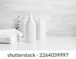 Soft light bathroom decor in white color, cosmetics product, towel, soap, dried flowers, accessories on white shelf. Elegant decor bathroom interior.