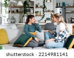 Small photo of Young women lesbian couple LGBTQ+ roommates having argue due the infidelity and cheating. Two girls in relationship having difficulty caused by jealousy. Marriage problems concept.