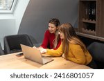 Small photo of Two young freelance business women teamwork working at home on laptop as product strategy expert. Female expatriate remote work on internet on computer online for foreign company as web developer.