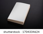 Book with blank cover on black background, editable mock up template ready for your design, clipping path included