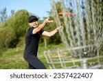 Man is throwing disc to the basket in disc golf