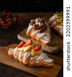 Small photo of Freshly baked croissants with berries jam, chocolat, dark wooden background