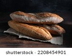 Fresh French baguettes on dark background. Side view.