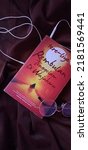 Small photo of The book entitled "The moon is sinking in your face" by Tere Liye, set in chocolate, glasses and earphones