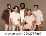 Small photo of Three quarter length studio portrait of five hansom men from diverse ethnic backgrounds posed smiling on a neutral background