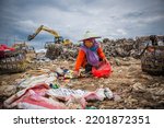 Small photo of Balikpapan, Indonesia, Nov 2020; a scavenger woman is sorting out items that are still fit for use or sale