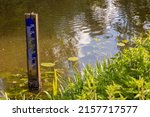 Water level depth meter, gauge or staff gauge, in the river. Extreme low water in river. Global warming. Shortage or lack of water due to hot temperatures. Government measurements. Crisis and climate.