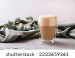Heat-resistant double-walled glass cup filled with latte or cappuccino