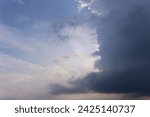 Small photo of This photo shows a view of a slightly cloudy sky with white clouds covering part of the sky. The sky was dark blue with fluffy, wispy white clouds. The slightly dim sunlight illuminated the entire sce